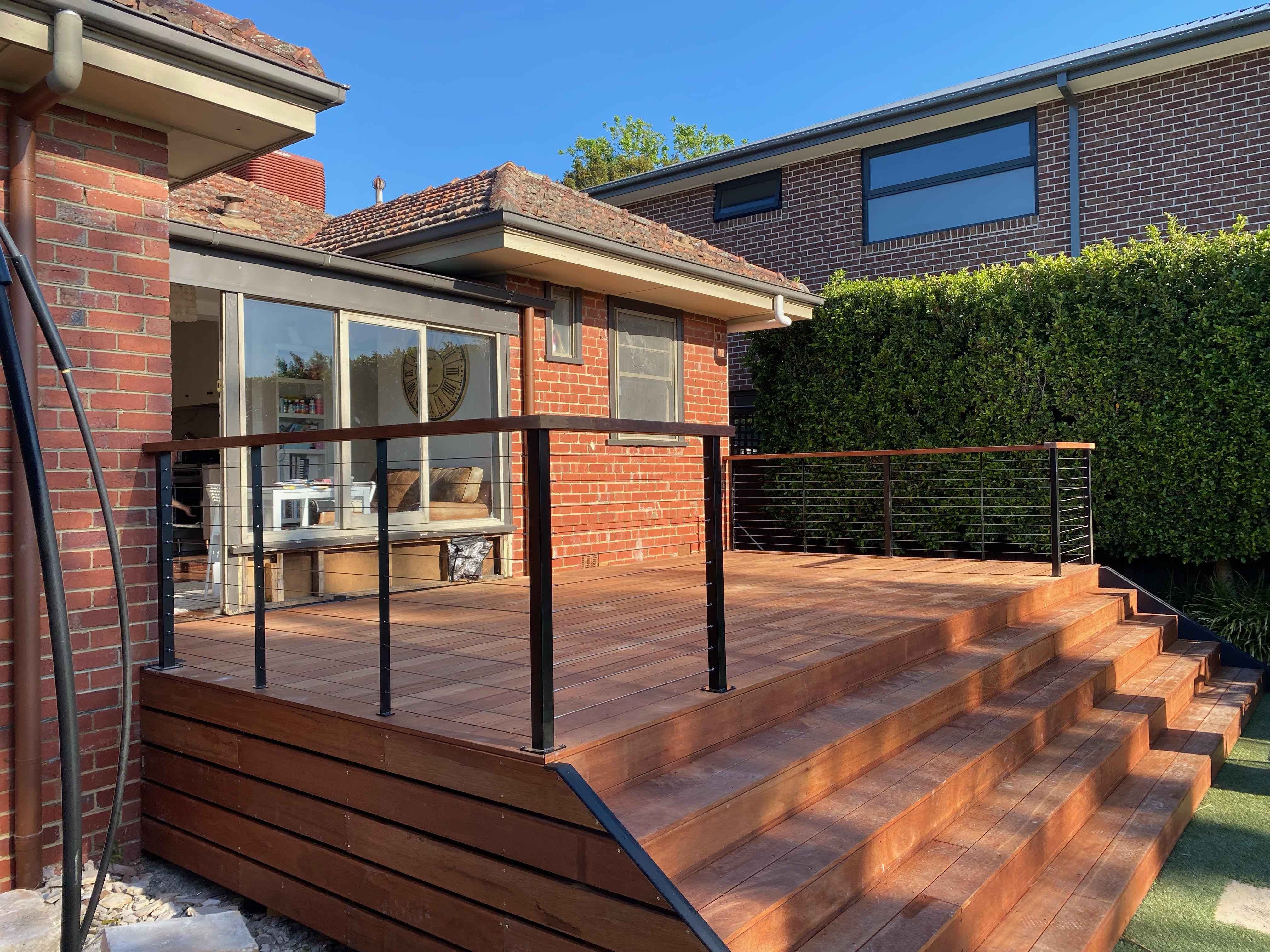 Inviting outdoor space with Black Posts & Wire Balustrade